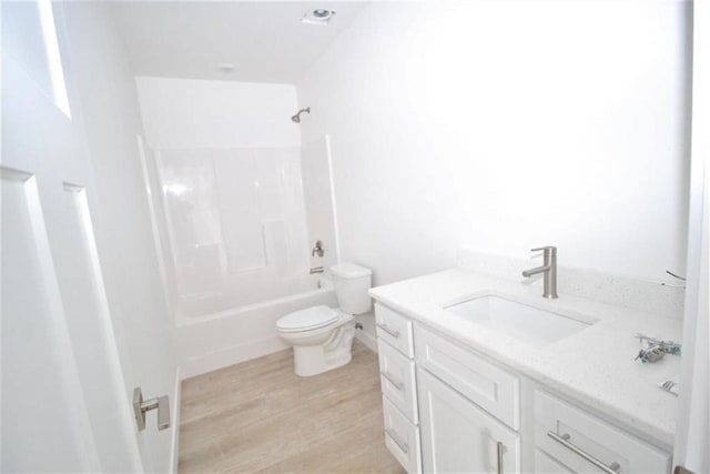 138 Mulberry Loop, Minot, ND 58703 - bathroom featuring wood finished floors, vanity, toilet, and bathtub / shower combination