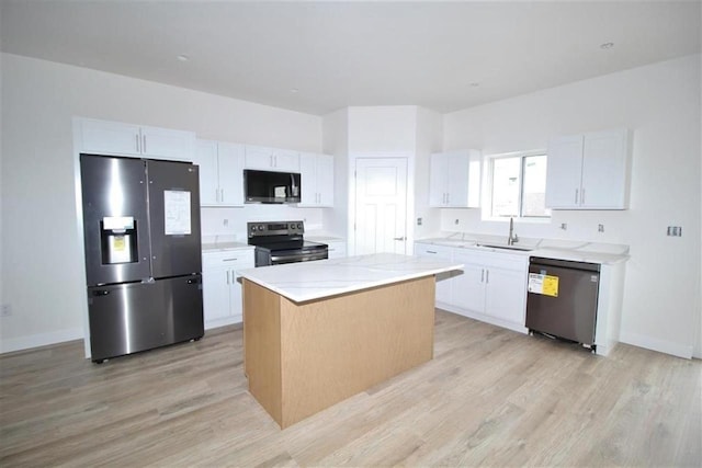 138 Mulberry Loop, Minot, ND 58703 - kitchen with stainless steel appliances, light wood finished floors, a kitchen island, and a sink