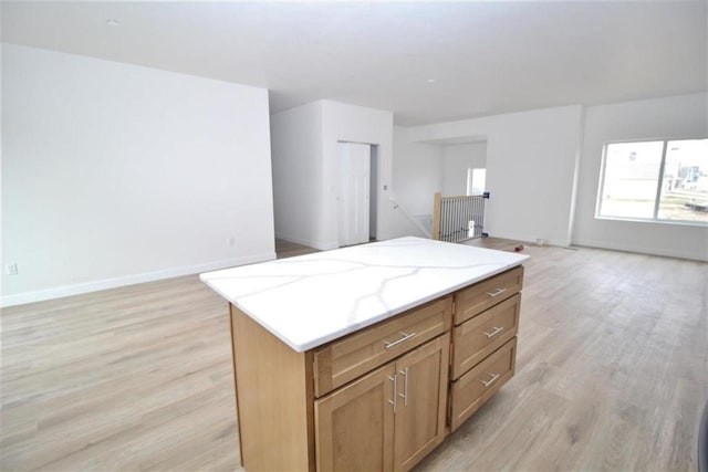 138 Mulberry Loop, Minot, ND 58703 - kitchen featuring open floor plan, light wood-style flooring, a kitchen island, and baseboards