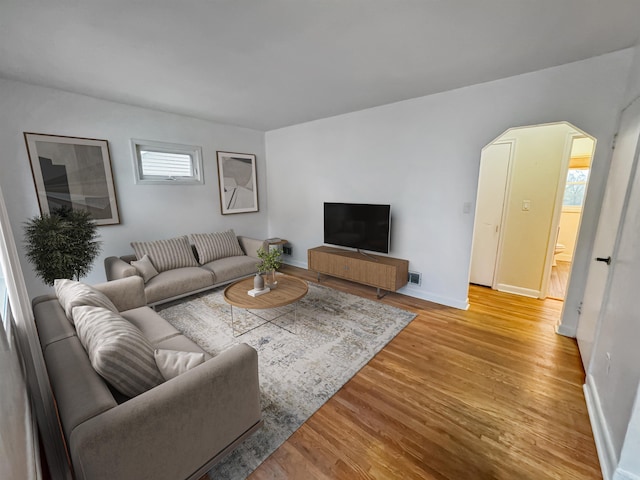 1201 Soo St, Minot, ND 58701 - living room with light wood-style flooring, arched walkways, and baseboards