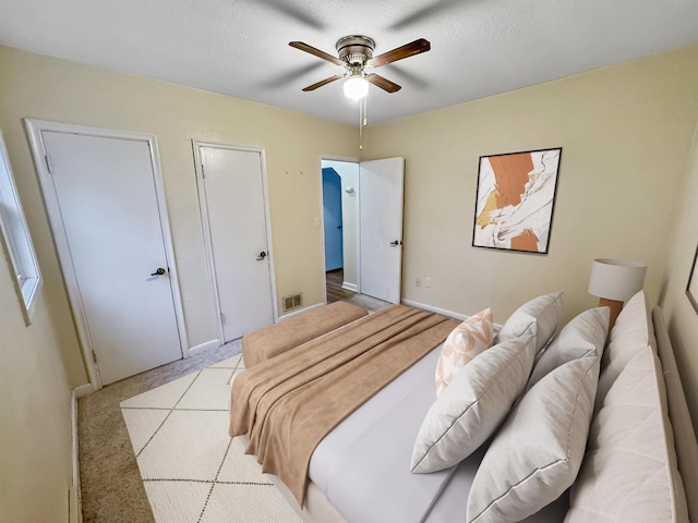 1201 Soo St, Minot, ND 58701 - bedroom featuring baseboards, ceiling fan, a textured ceiling, and light colored carpet