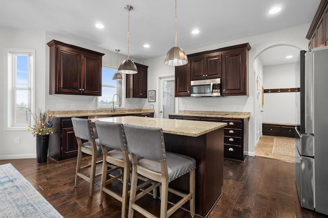 1804 Valley Bluffs Dr, Minot, ND 58701 - kitchen with stainless steel appliances, a kitchen island, dark wood finished floors, baseboards, and recessed lighting