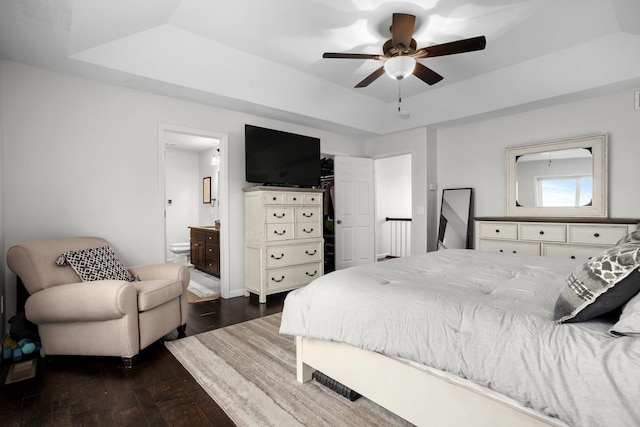 1804 Valley Bluffs Dr, Minot, ND 58701 - bedroom with a raised ceiling, dark wood-style floors, connected bathroom, and ceiling fan
