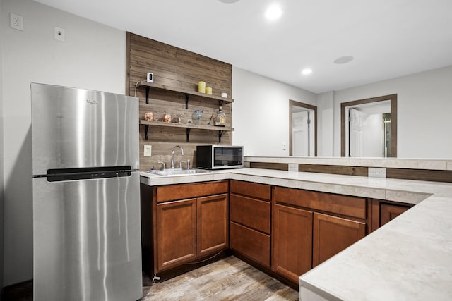 1804 Valley Bluffs Dr, Minot, ND 58701 - kitchen with freestanding refrigerator, a sink, light countertops, light wood finished floors, and recessed lighting