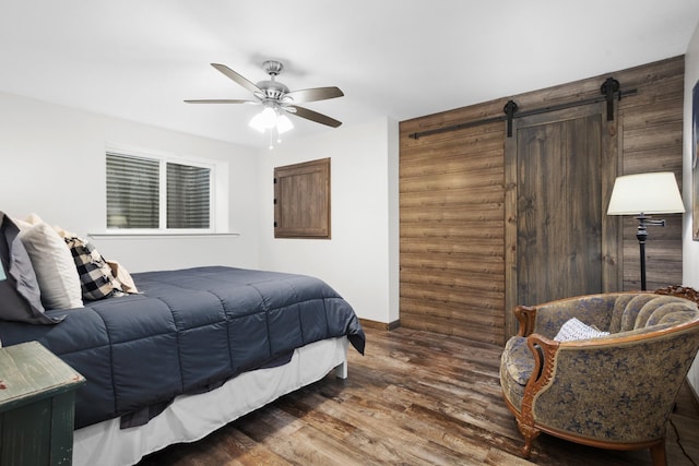 1804 Valley Bluffs Dr, Minot, ND 58701 - bedroom featuring a barn door, wood finished floors, baseboards, and ceiling fan