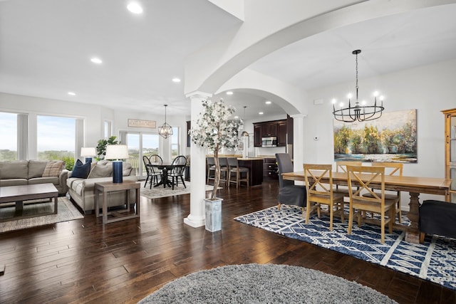 1804 Valley Bluffs Dr, Minot, ND 58701 - dining space with a chandelier, recessed lighting, dark wood-style floors, arched walkways, and ornate columns