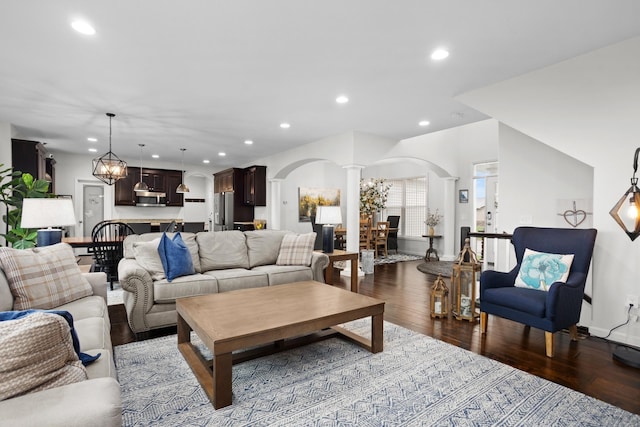 1804 Valley Bluffs Dr, Minot, ND 58701 - living area featuring decorative columns, arched walkways, recessed lighting, baseboards, and dark wood-style floors