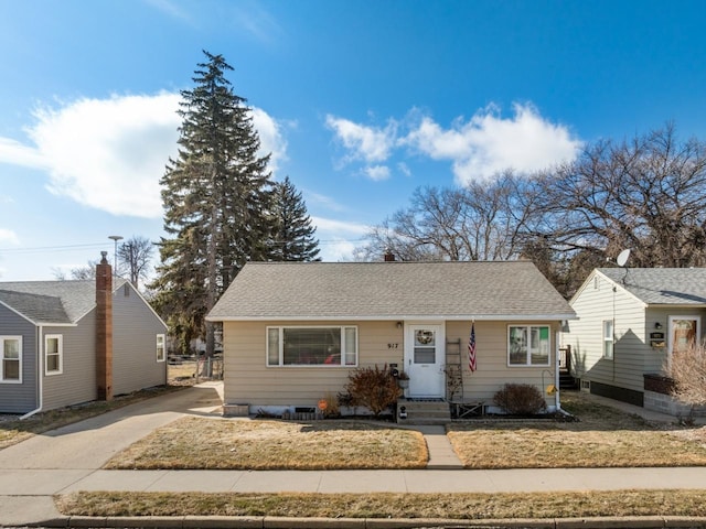 917 17th St Unit 0, Minot, ND 58703 - bungalow-style house with concrete driveway, a front lawn, entry steps, and roof with shingles