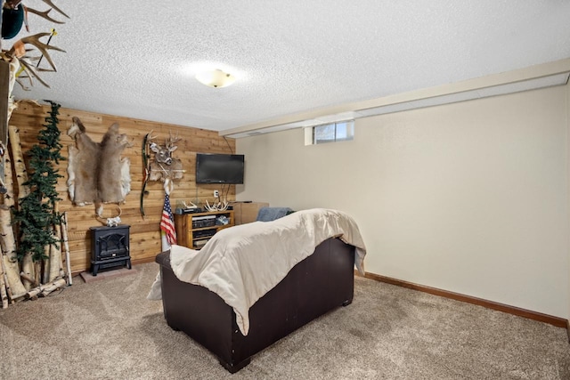 917 17th St Unit 0, Minot, ND 58703 - carpeted living room featuring wooden walls, a wood stove, a textured ceiling, and baseboards