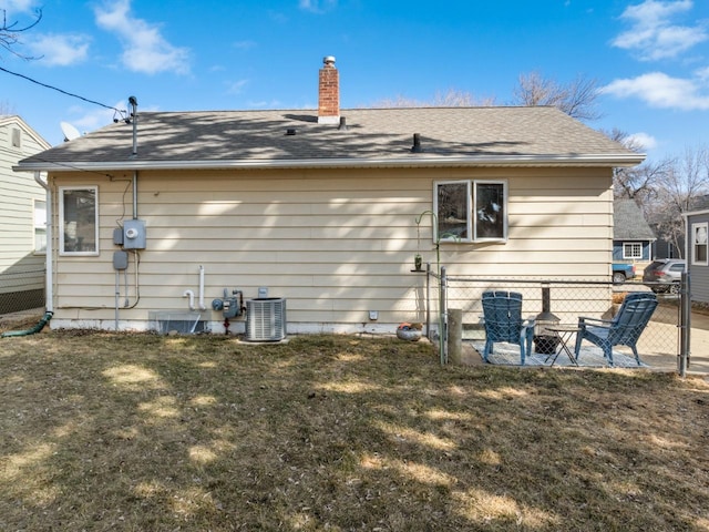 917 17th St Unit 0, Minot, ND 58703 - rear view of house featuring a chimney, central air condition unit, and a shingled roof