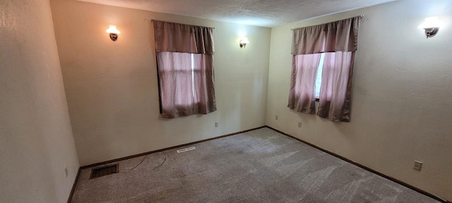 101 Central Ave, Des Lacs, ND 58733 - spare room with carpet flooring, baseboards, and a textured ceiling