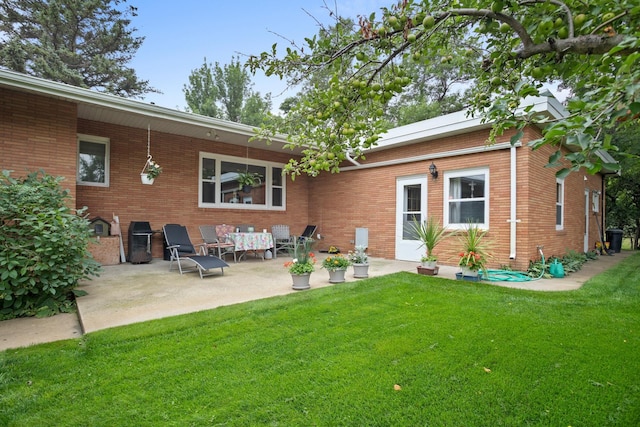 10010 128th St, Burlington, ND 58722 - rear view of property with a yard, brick siding, and a patio area