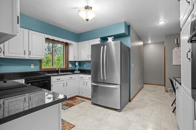 3900 16th St, Minot, ND 58703 - kitchen featuring freestanding refrigerator, a sink, black dishwasher, white cabinetry, and a textured ceiling