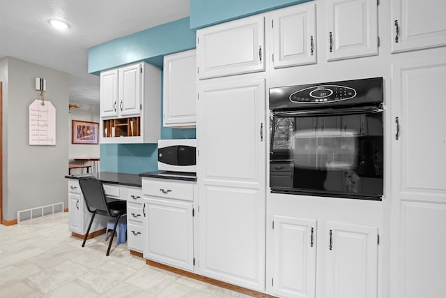 3900 16th St, Minot, ND 58703 - kitchen with black oven, white cabinetry, open shelves, dark countertops, and baseboards