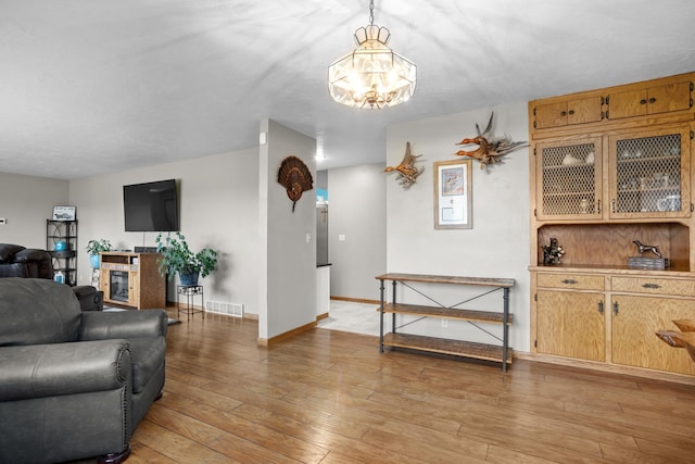 3900 16th St, Minot, ND 58703 - living area with a chandelier, light wood-style floors, and baseboards