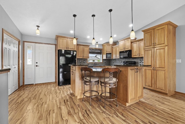 625 34th Ave Unit A, Minot, ND 58701 - kitchen with black appliances, light wood-style flooring, dark countertops, and backsplash