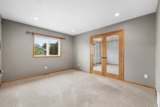 625 34th Ave Unit A, Minot, ND 58701 - carpeted spare room featuring french doors, baseboards, and recessed lighting