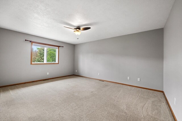 625 34th Ave Unit A, Minot, ND 58701 - empty room with ceiling fan, light colored carpet, a textured ceiling, and baseboards