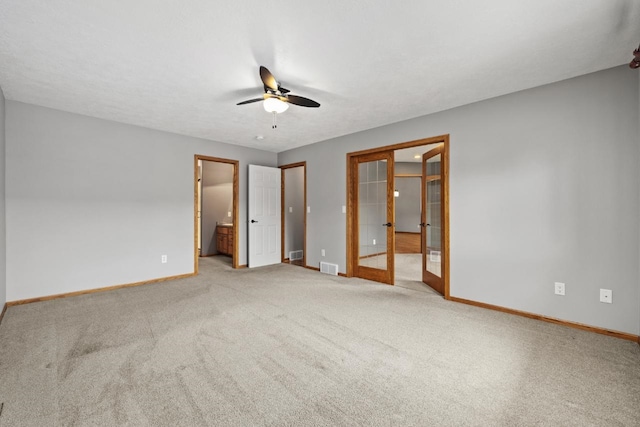 625 34th Ave Unit A, Minot, ND 58701 - unfurnished bedroom featuring baseboards, connected bathroom, french doors, carpet floors, and ceiling fan
