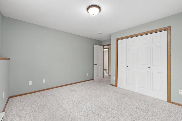625 34th Ave Unit A, Minot, ND 58701 - unfurnished bedroom with carpet flooring, baseboards, and a closet