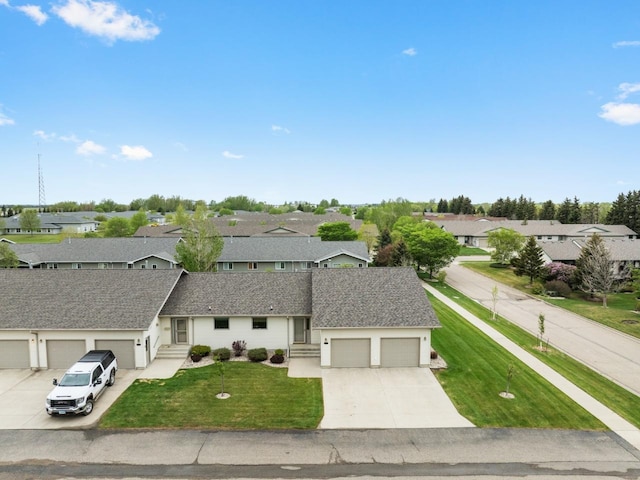 625 34th Ave Unit A, Minot, ND 58701 - ranch-style house with a residential view, concrete driveway, a garage, and a front yard
