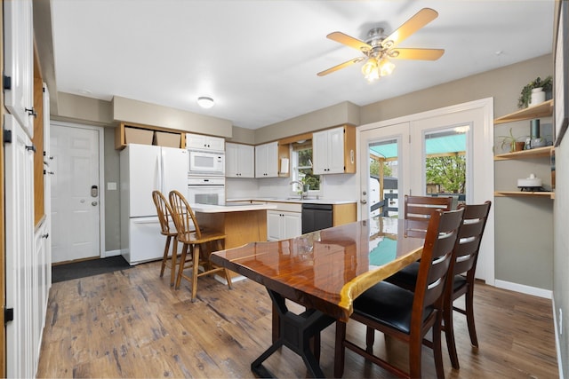 1816 7th St, Minot, ND 58703 - dining room with a ceiling fan, dark wood-style floors, and baseboards