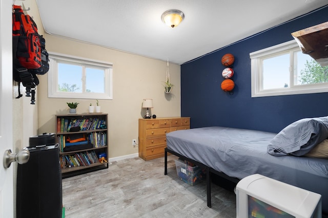 1816 7th St, Minot, ND 58703 - bedroom featuring wood finished floors, multiple windows, and baseboards