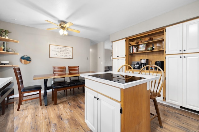 1816 7th St, Minot, ND 58703 - kitchen with open shelves, a center island, light wood finished floors, ceiling fan, and white cabinetry