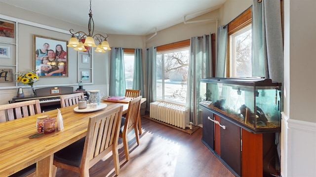 200 E 1st St, Velva, ND 58790 - dining room with radiator heating unit, wood finished floors, a chandelier, a wainscoted wall, and a decorative wall