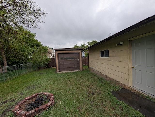 807 NW 8th St, Minot, ND 58703 - view of yard with an outdoor structure, an outdoor fire pit, driveway, and a garage