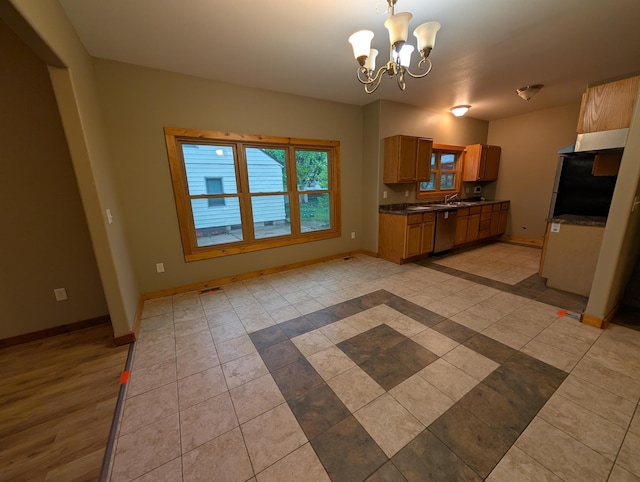 807 NW 8th St, Minot, ND 58703 - kitchen with stainless steel dishwasher, dark countertops, and baseboards