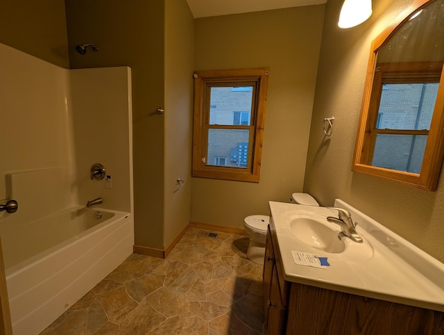 807 NW 8th St, Minot, ND 58703 - bathroom featuring vanity, shower / washtub combination, toilet, and baseboards