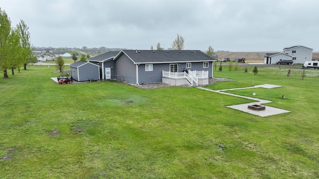 3030 Mustang Trl, Minot, ND 58703 - back of house with an outdoor fire pit, a wooden deck, and a yard