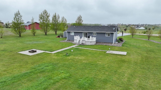 3030 Mustang Trl, Minot, ND 58703 - rear view of property with an outdoor fire pit, a deck, and a lawn