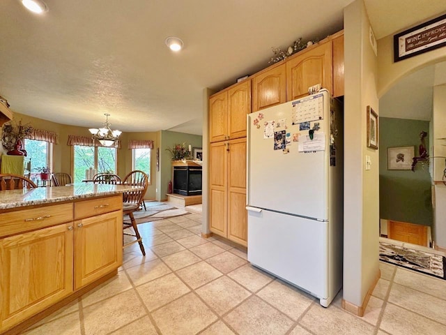 2900 8th St, Minot, ND 58701 - kitchen with freestanding refrigerator, a chandelier, recessed lighting, arched walkways, and baseboards