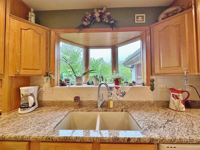 2900 8th St, Minot, ND 58701 - kitchen with a sink, decorative backsplash, and light stone counters