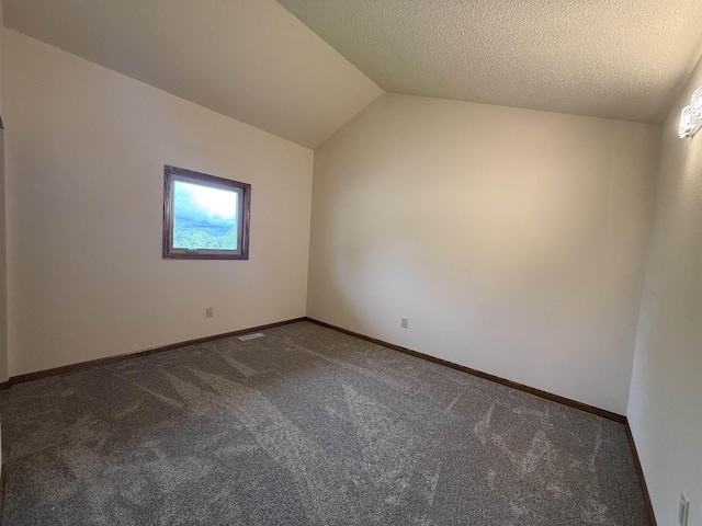 1003 NW Harrison Dr, Minot, ND 58703 - carpeted empty room featuring vaulted ceiling and baseboards