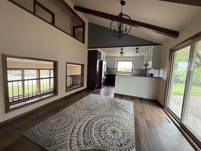 1003 NW Harrison Dr, Minot, ND 58703 - kitchen with freestanding refrigerator, decorative backsplash, a chandelier, a peninsula, and dark wood-style floors