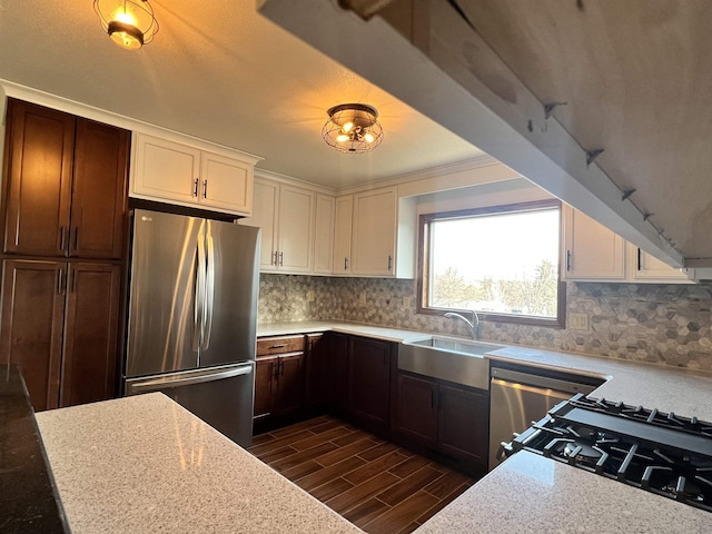 1003 NW Harrison Dr, Minot, ND 58703 - kitchen featuring freestanding refrigerator, dark wood finished floors, tasteful backsplash, white cabinetry, and gas stove