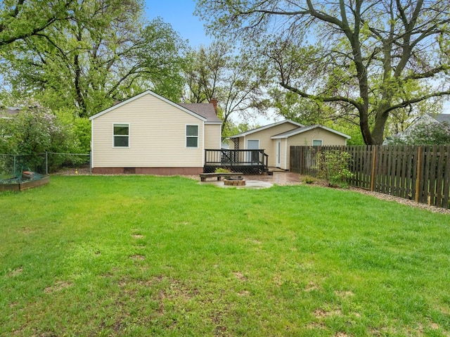 1111 15th St, Minot, ND 58703 - back of property featuring a wooden deck, a chimney, and an outdoor fire pit