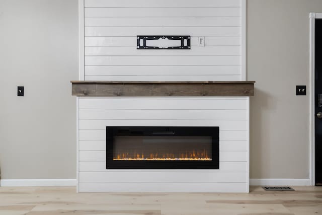 1111 15th St, Minot, ND 58703 - detailed view of a fireplace, baseboards, and wood finished floors