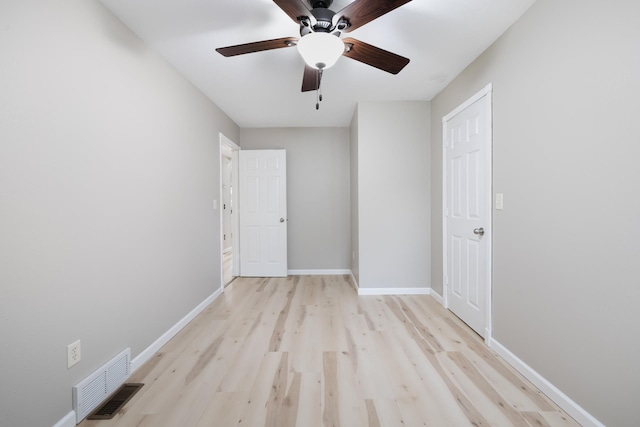 1111 15th St, Minot, ND 58703 - unfurnished bedroom featuring light wood-style floors, baseboards, and a ceiling fan