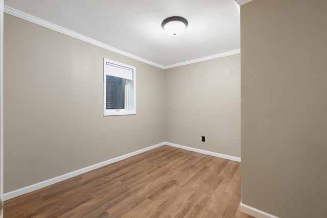 1111 15th St, Minot, ND 58703 - spare room featuring crown molding, light wood-type flooring, and baseboards