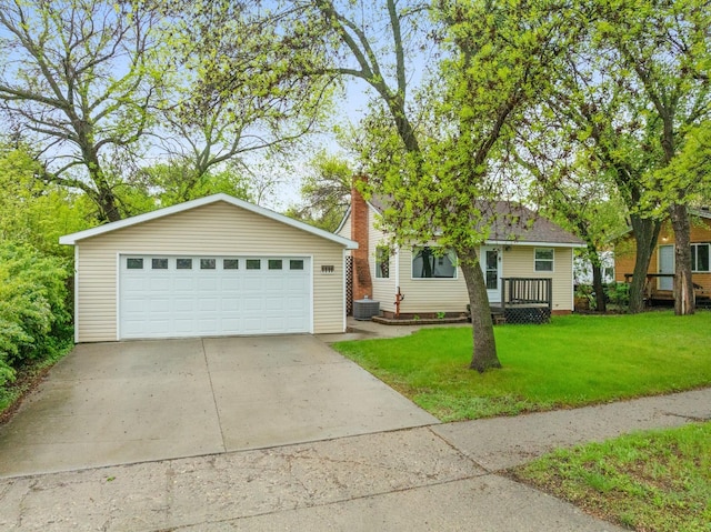 1111 15th St, Minot, ND 58703 - view of front of house with a front yard, a garage, cooling unit, and an outbuilding