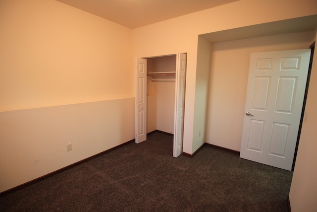 1512 47th Loop, Minot, ND 58701 - unfurnished bedroom with dark colored carpet, a closet, and baseboards