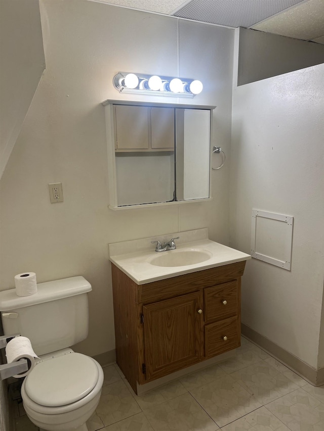 912 Valley St, Minot, ND 58701 - half bathroom featuring vanity, toilet, and baseboards
