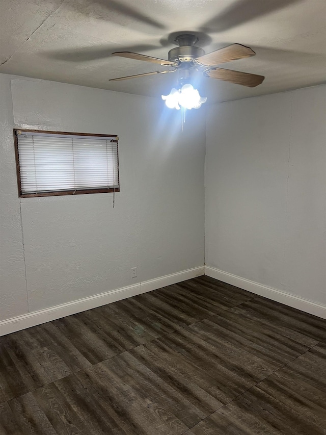 912 Valley St, Minot, ND 58701 - spare room with a ceiling fan, dark wood-style floors, and baseboards