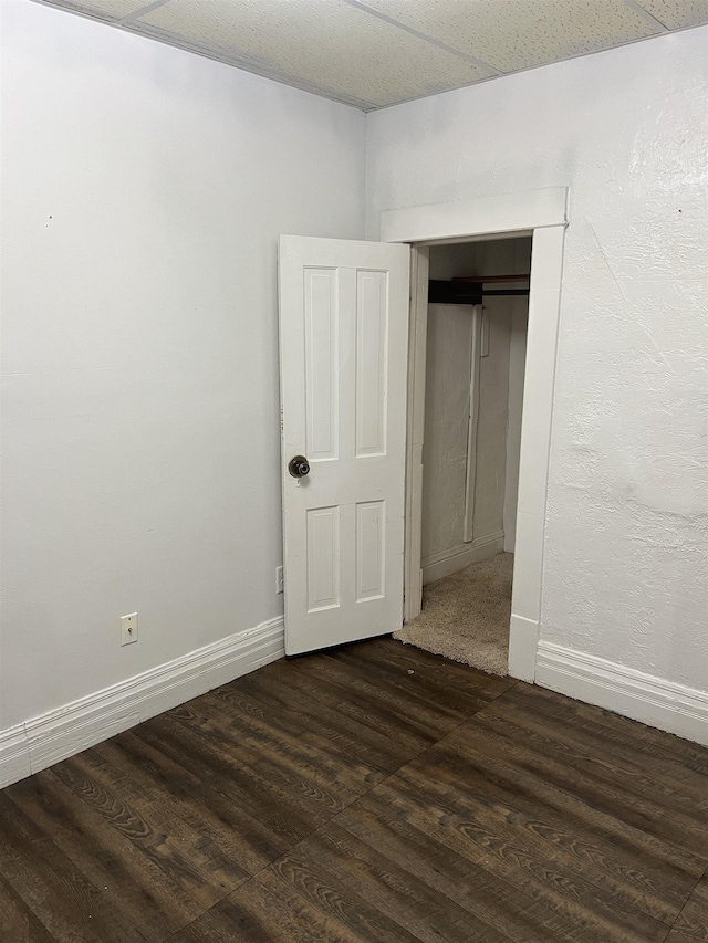 912 Valley St, Minot, ND 58701 - unfurnished bedroom with dark wood-style floors, baseboards, and a closet