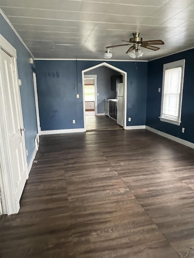 912 Valley St, Minot, ND 58701 - unfurnished living room with a ceiling fan, healthy amount of natural light, dark wood finished floors, crown molding, and baseboards