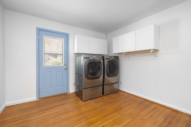 1200 9th St, Minot, ND 58703 - laundry area featuring separate washer and dryer, baseboards, light wood-type flooring, and cabinet space